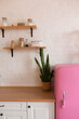 © sergiophoto - Kitchen shelves, wooden surface and pink fridge on white background. White kitchen interior counter top.