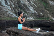 © Pablo Garcia/ADDICTIVE STOCK - Side view of slim female sitting on rock and meditating with Namaste hands while relaxing during yoga practice and looking away