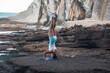 © Pablo Garcia/ADDICTIVE STOCK - Back view of tranquil female balancing in Salamba Sirsasana on rocky beach while practicing yoga in summer