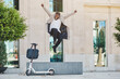 © Philippe Degroote/ADDICTIVE STOCK - Delighted African American guy in casual outfit in moment of jumping above street with electric scooter in city