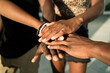 © Rafa Cortes/ADDICTIVE STOCK - High angle of crop unrecognizable African American company of friends stacking hands together on street on sunny day
