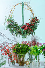 Handmade Creative Floral Wreath And Assorted Flowers Placed In Glasses With Water In Salon