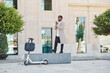 © Philippe Degroote/ADDICTIVE STOCK - Side view of african American guy in casual outfit standing on the street with electric scooter in city