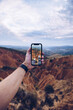 © Ruben Soto/ADDICTIVE STOCK - Crop unrecognizable male hiker shooting picture of eroded mountainous landscape on mobile phone while travelling through highlands and exploring wild nature