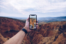 Crop Unrecognizable Male Hiker Shooting Picture Of Eroded Mountainous Landscape On Mobile Phone While Travelling Through Highlands And Exploring Wild Nature