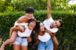 © Picua Estudio/ADDICTIVE STOCK - Delighted women piggybacking female friends and laughing on street while having fun and enjoying weekend together