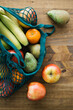 © Ramon Lopez/ADDICTIVE STOCK - Top view of assorted fresh fruit in cotton eco friendly sacks placed on wooden table