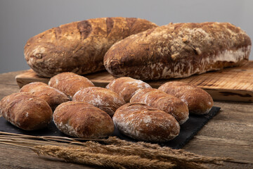 Fresh bread loafs with crispy and golden crust on wooden board