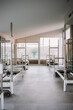 © Raquel Arocena/ADDICTIVE STOCK - Bright interior of gym with contemporary pilates reformers placed in spacious facility for workouts