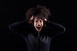 © Txema Gerardo/ADDICTIVE STOCK - Stressful angry young African American female with curly hair shouting loudly and touching head while standing against black background