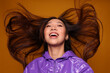 © Victor Torres/ADDICTIVE STOCK - Portrait of Asian young woman with serious expression. She wears a purple jacket and a gray cap and is looking at the camera against a yellow background