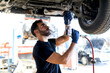 © Sergio Victor Vega/ADDICTIVE STOCK - Busy male technician using special instrument and fixing car while working in modern service