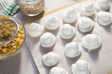 Top view of a board with homemade marshmallows made from Aquafaba chickpeas. The concept of preparing protein products by using vegetable proteins