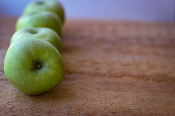 Wall Mural - Green apples stand on a wooden surface