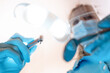 Zahnarzt / Zahnärztin mit Bohrer und OP Leuchte aus Sicht des Patienten dicht über dem Mund mit Corona Maske
