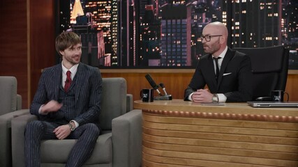 Wall Mural - Late-night talk show host having a funny conversation with celebrity male guest in a studio. TV broadcast style show. Shot with RED cinema camera