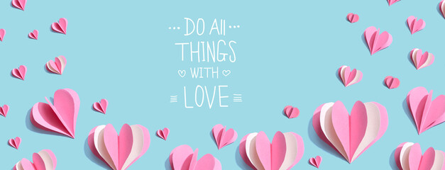 Do all things with love message with pink paper hearts - flat lay