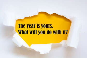 Wall Mural - Motivational quote The year is yours. What will you do with it? appearing behind torn white paper.