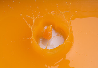 Wall Mural - falling of orange piece into juice,splash orange juice