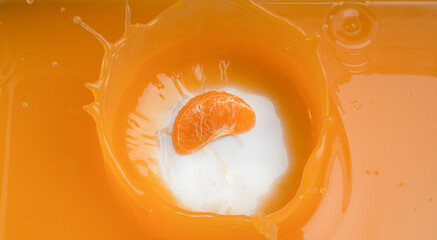 Wall Mural - falling of orange piece into juice,splash orange juice