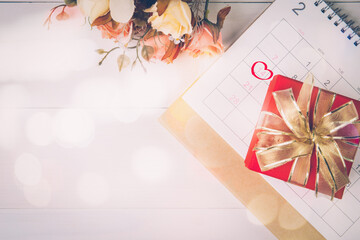 Wall Mural - Calendar and flower with memo 14 February Valentine day on desk with blur bokeh background, reminder for surprise of love, romance and sweet, celebration and decoration, top view, holiday concept.