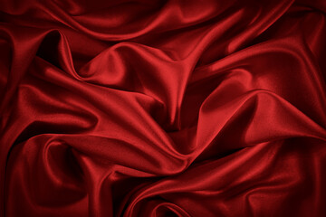  Red silk satin background. Beautiful soft wavy folds on smooth shiny fabric. Anniversary, Christmas, wedding, valentine, event, celebration concept. Red luxury background with copy space for design. 