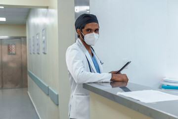 Doctor checking his tablet in the corridor of a hospital