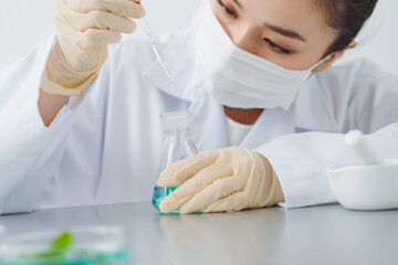 Wall Mural - Lab worker dripping water into flask with leaf on blurred background, closeup