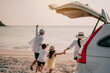 © Garun Studios - Asian family vacation holiday, Happy family running on the beach in the sunset.Happy family is running into the sea.Back view of a happy family on a tropical beach and a car on the side.
