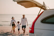 © Day Of Victory Stu. - Asian family vacation holiday, Happy family walking on the beach in the sunset.Happy family is walking into the car.Back view of a happy family on a tropical beach and a car on the side.