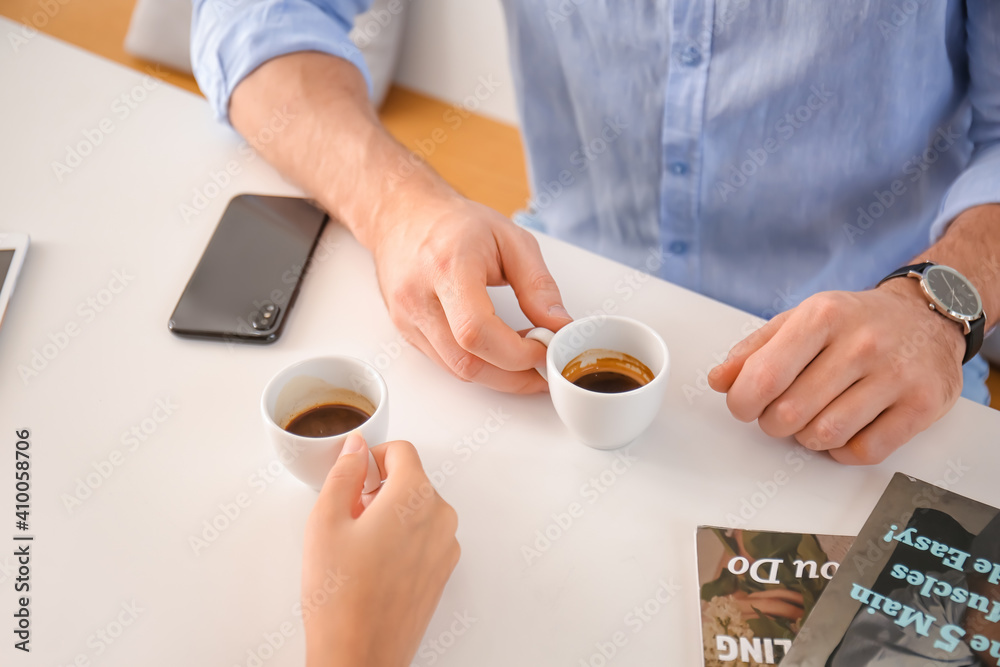 Happy couple drinking hot espresso on romantic date in cafe