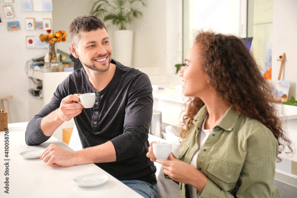 Happy couple drinking hot espresso on romantic date in cafe