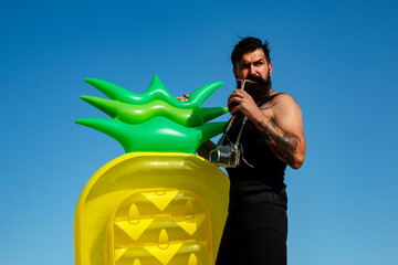 Man with inflatable mattress. Handsome man in swimsuit. Guy summer.