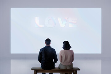 Couple watching  love movie projecting on the wall rear view