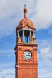 Close up clock tower outside Bolton Railway Station with blue sky background, England, UK