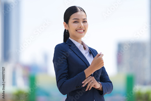 Portrait of smiling business woman while standing in front of modern office © Naypong Studio