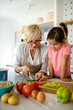 Grandmother and granddaughter are cooking on kitchen. Family fun love generation concept
