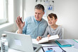 © epiximages - Father working from home having a video call while son doing homework.