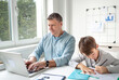 © epiximages - Business man works from home doing homeoffice and his son has homeschooling during corona crisis