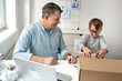 © epiximages - Online shopping concept. Dad and son open a package from an online company during corona crisis.