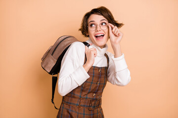 Poster - Photo of young attractive lovely sweet nice happy smiling girl in glasses look copyspace isolated on beige color background