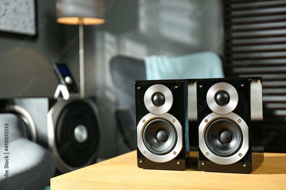 Modern audio speaker system on wooden table in living room