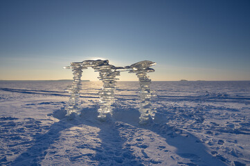 Wall Mural - a sculpture made of pieces of ice against the backdrop of a sunset, on the shore.