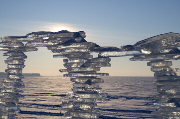 Wall Mural - a sculpture made of pieces of ice against the backdrop of a sunset, on the shore.