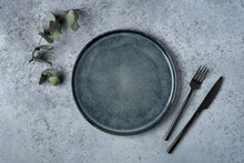 An Empty Plate And Cutlery On A Gray Table. Top View.
