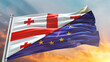 European Union Flag and Georgia flag waving with texture sky Cloud and sunset Double flag
