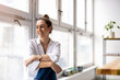 © pikselstock - Portrait of a smiling creative woman in a modern loft space