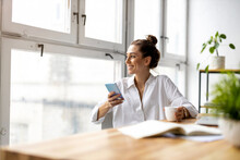 Creative Business Woman Using Smartphone In Loft Office
