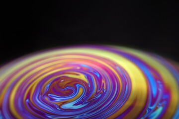 Wall Mural - macro picture of half soap bubble on black ground look like abstract psychedelic color planet in spa