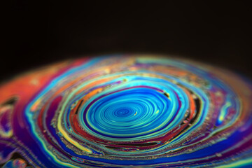 Wall Mural - macro picture of half soap bubble on black ground look like abstract psychedelic color planet in spa
